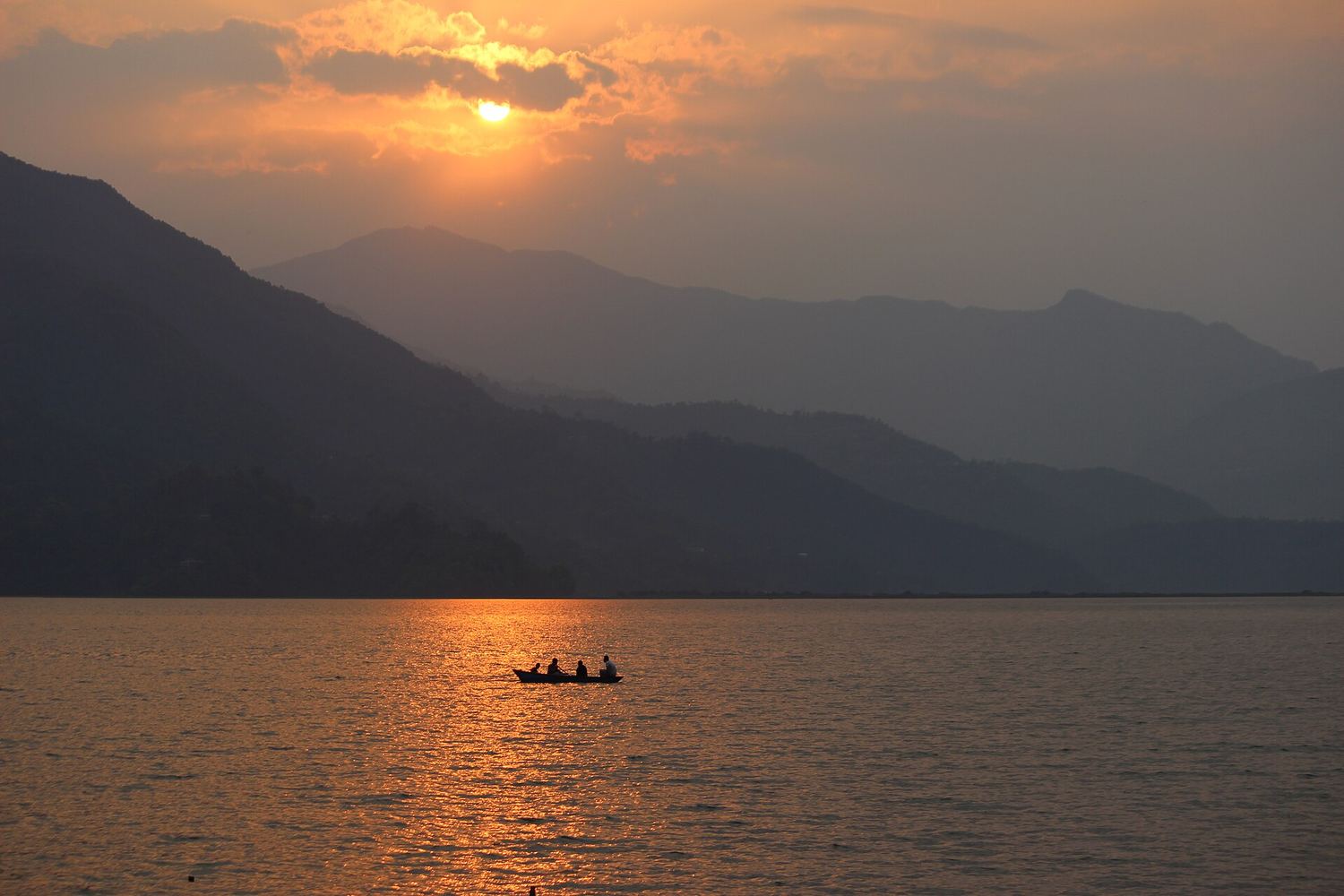 Sunset over Phewa Lake in Pokhara with hills behind